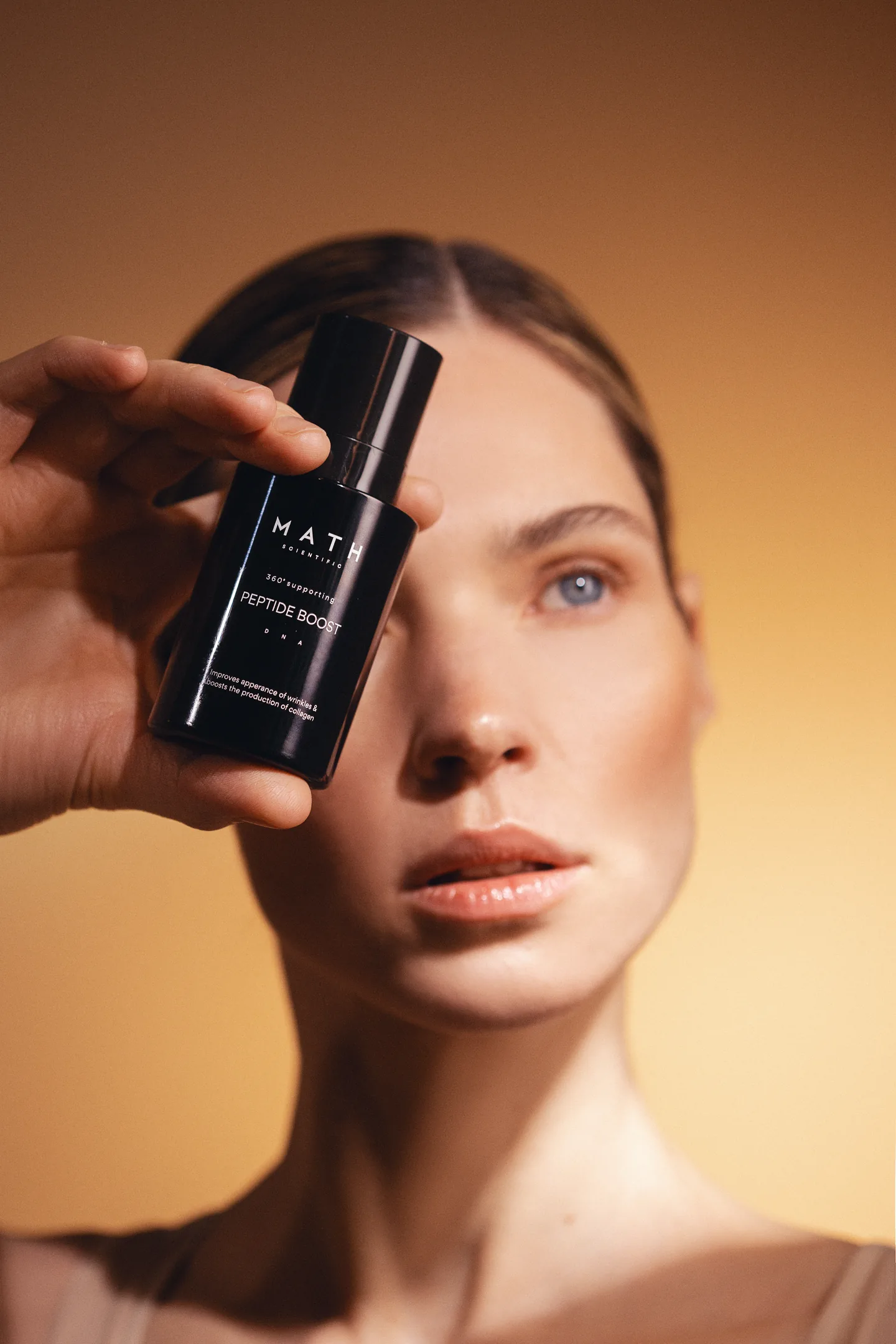 Kobieta trzymająca serum MATH Scientific Peptide Boost